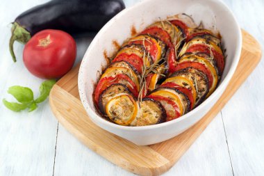 Cooked ratatouille in the foreground, vegetables in the background.The concept of cooking healthy homemade food.