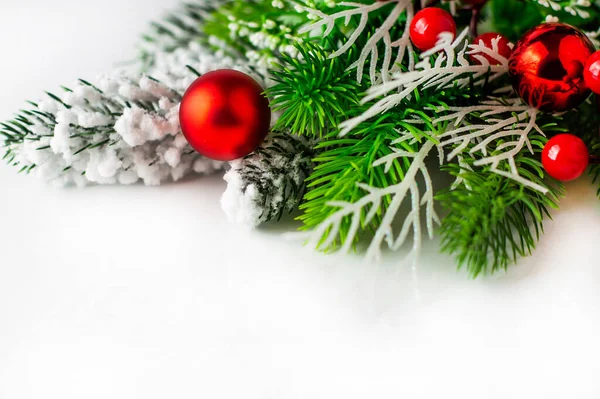 stock image On a white background, fir branches with snow and red Christmas balls. Christmas background.