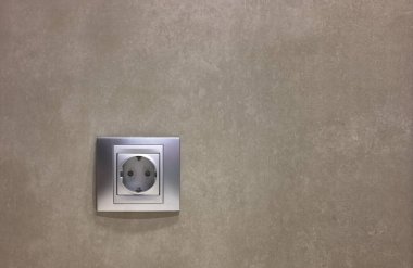 Seramik fayanslı duvardaki metalize bir elektrik prizinin ayrıntıları