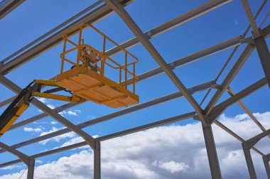 Metal bir yapının inşası için sarı bir yükseltme platformunun ayrıntıları