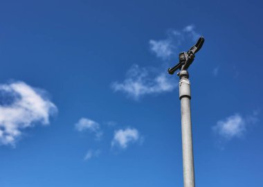 Fıskiye sulama için bir su fıskiyesinin ayrıntıları. Arkasında bulutlu mavi bir gökyüzü olan tahıl fidanlığı.