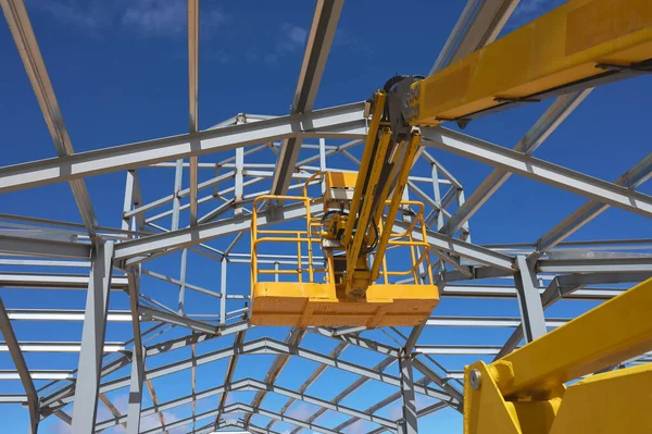 Metal bir yapının inşası için sarı bir yükseltme platformunun ayrıntıları