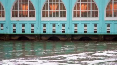 Bir kuş barajın üzerinden uçuyor, köpük içinde.