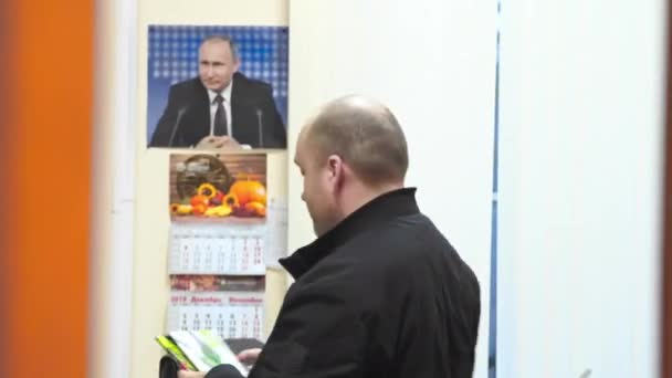 A man leaves the office in the background putin — Stock Video