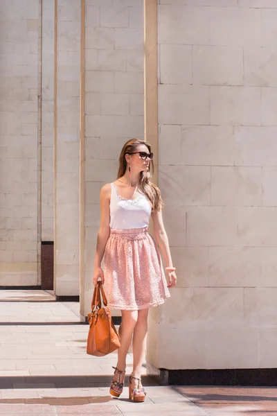 Beautiful brunette young woman wearing dress and walking on the street — Stock Photo, Image