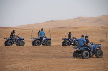 18 Kasım 2021 Dubai, BAE - Arap Yarımadası 'nın en büyüğü olan Dubai' deki Rub al Khali Çölü 'nün kum tepelerinde ATVlere binen bir grup insan