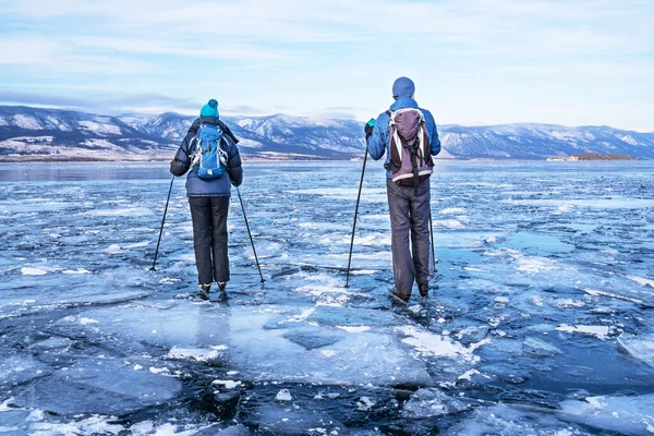 Turistler Baykal Gölü 'nün buzunda kayıyorlar. Özellikle göllerde, nehirlerde, kanallarda ve koylarda paten kaymak için tasarlanmış İskandinav patenleri. aktif dinlenme. Kış tatili ve seyahat kavramı