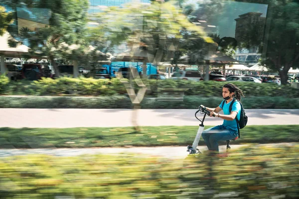 stock image November 17, 2021 UAE, Dubai. Teenager rides a scooter in the park