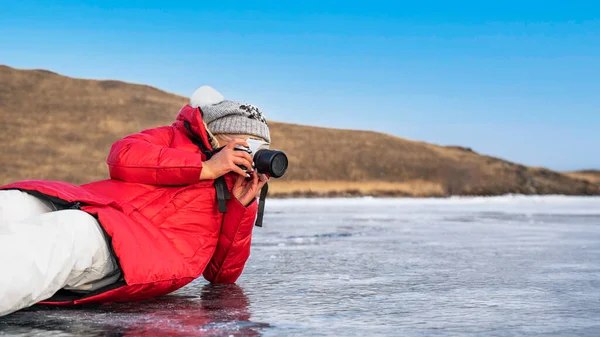 Fotografo turistico con una macchina fotografica sul ghiaccio del lago Baikal — Foto Stock