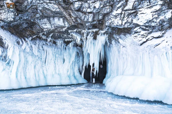 Tourists in a grotto on the winter coast of Lake Baikal. — Stock Photo, Image