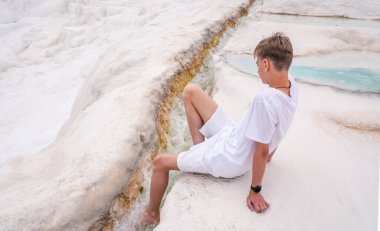 Beyaz tişörtlü ve şortlu genç, doğal havuz Pamukkale