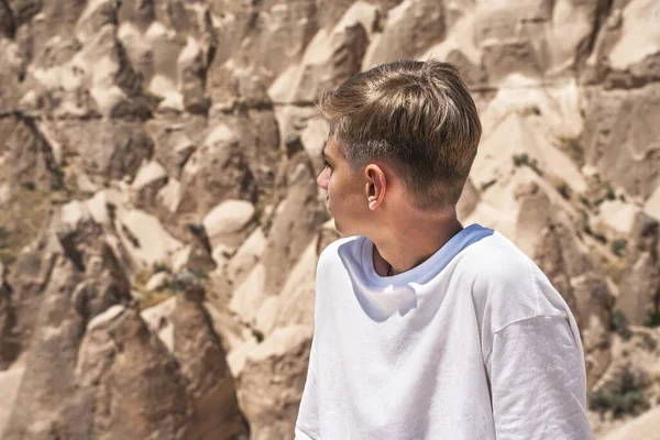 Adolescent devant les formations rocheuses de la Cappadoce en Turquie avec un paysage fabuleux et désertique. Photo De Stock