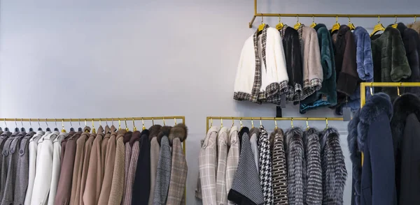 Manteaux de printemps pour femmes suspendus sur un rack dans un magasin de vêtements pour femmes Images De Stock Libres De Droits
