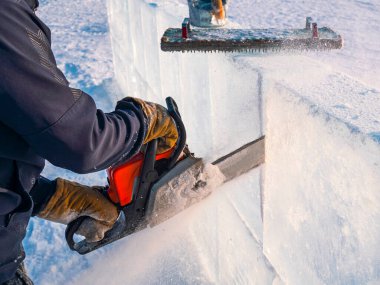 Buzdan heykeller yapıyorlar. Bir adam Baykal Gölü 'nün yüzeyini benzin testeresiyle buz kalıbıyla kesiyor..