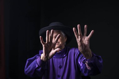 Yaşlı bir kadının avucunun içinde, siyah bir arka plan..