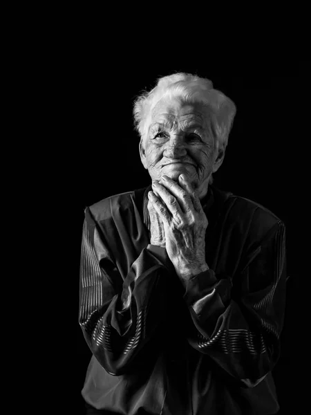 Portret poważnej starszej kobiety na czarnym tle. Czarno-białe zdjęcie. — Zdjęcie stockowe