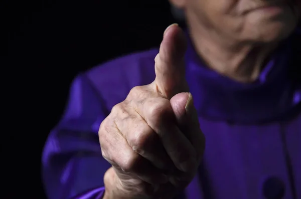 Anciana dama es sacudiendo su fingera negro fondo. — Foto de Stock