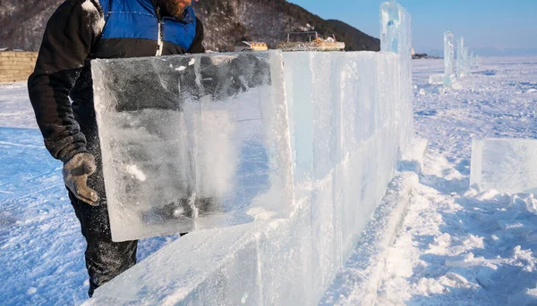 Scultore costruisce un muro da un blocco di ghiaccio sul lago Baikal. — Foto Stock