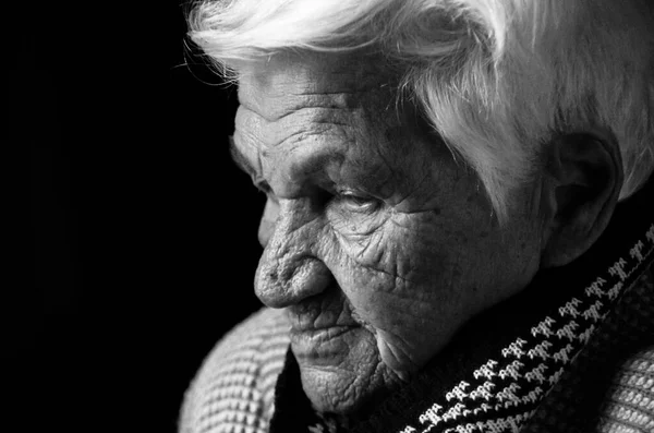 Retrato de una mujer mayor seria sobre fondo negro. Foto en blanco y negro. — Foto de Stock