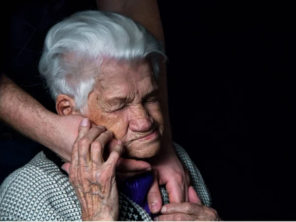 Ręce starszej kobiety na czarnym tle. — Zdjęcie stockowe