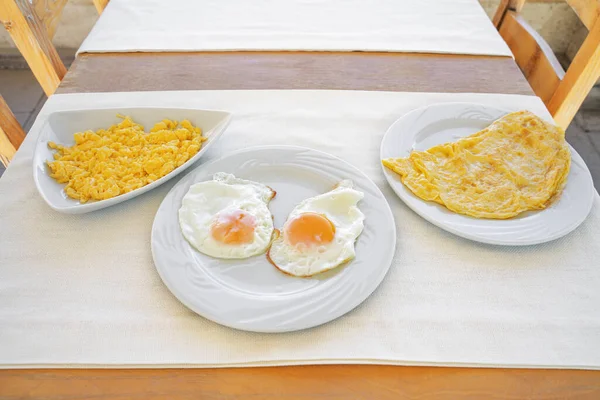 Various ways to cook chicken eggs. Boiled omelet, scrambled eggs and fried omelet. Close-up.