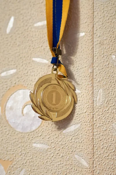 Close-up of the gold medal for the first place in the competition hanging on the wall