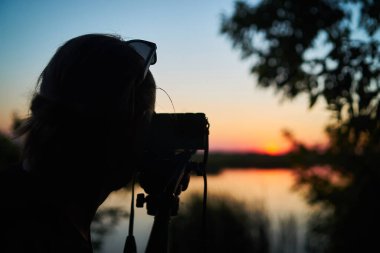 Bir fotoğrafçı yaz günbatımını arkadan çeker.