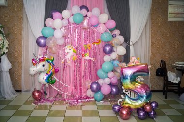 Şişme toplar ve pembe tonlu tek boynuzlu bir atla 5 yıl boyunca şenlikli fotoğraf bölgesi.