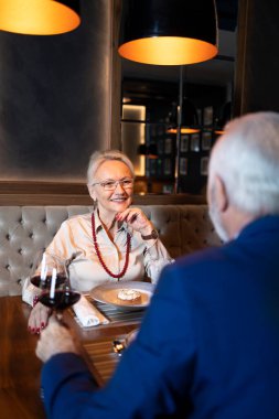 Ortağıyla restoranda yemek yiyen zarif bir kadın.
