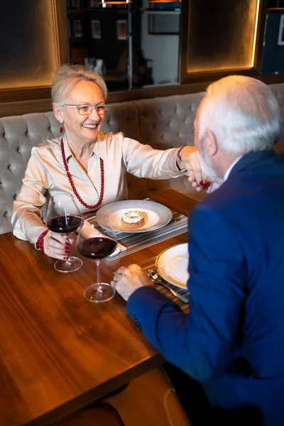 Partneri elini öperken zarif bir kadın gülümsüyor.