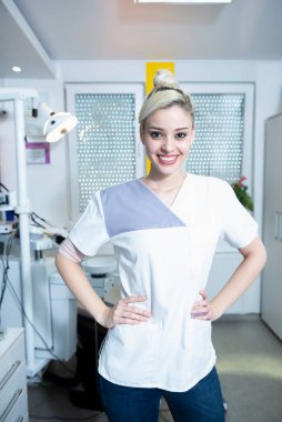 Kliniğinde gülümseyen kadın dişçi.