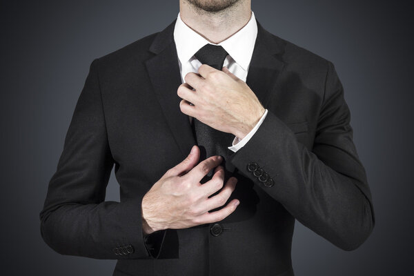 Businessman correcting tie