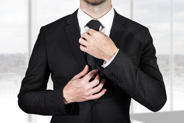 businessman correcting necktie