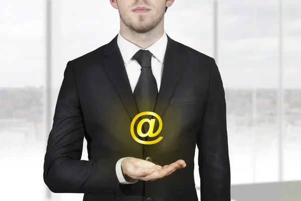 Businessman holding web at symbol in hand — Stock Photo, Image
