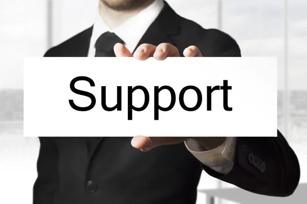 Affärsman hålla tecken stöd — Stockfoto