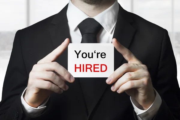 Businessman holding sign you are hired — Stock Photo, Image