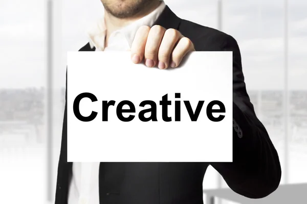 Biznesmen posiadający znak kreatywnych — Zdjęcie stockowe
