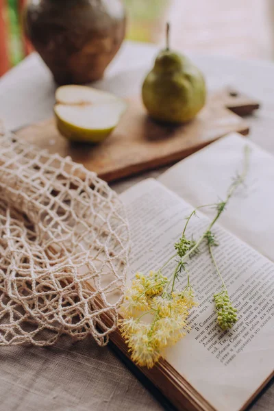 Armutlarla dolu sakin bir hayat ve kırsal tarzda keten masa üzerine bir kitap, tahıllı bir fotoğraf ve seçici bir odaklanma.
