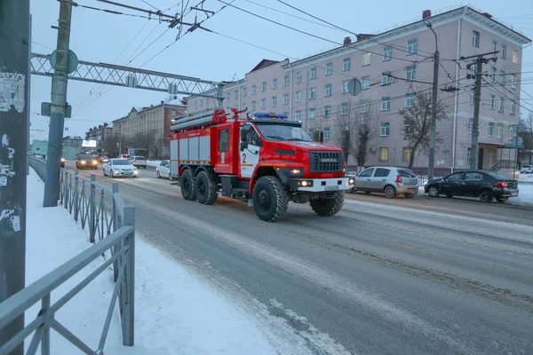 Omsk, Rusya - 28 Aralık 2021: Sabahın erken saatlerinde bir itfaiye aracı acil çağrıdan dönüyor                        