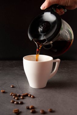 Filling a coffee cup with coffee in slow motion on a concrete background