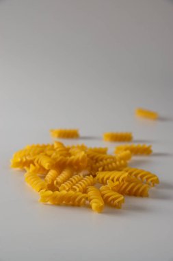 Fusilli italian pasta scattered freely on a white background