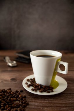 Coffee cup on a wooden table with wallet and watch
