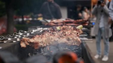 Siyah eldivenli bir adamın elleri ateşte barbekü yapıyor.