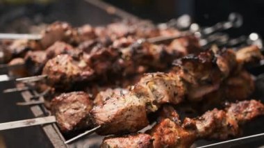 Siyah eldivenli bir adamın elleri ateşte barbekü yapıyor.