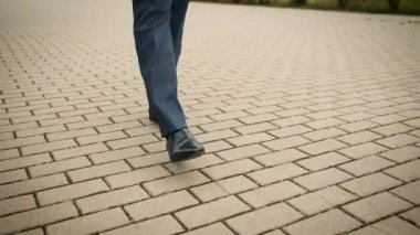 Portrait of legs of a man going to a business meeting in a suit. Stylish man in black shoes