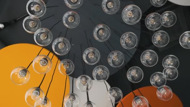 Дорогостоящая большая стеклянная люстра в ресторане или концертном зале, снятая с размытым фокусом и отражениями — стоковое видео