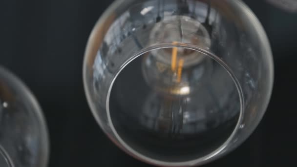 Drogi duży szklany żyrandol w restauracji lub sali koncertowej, nakręcony z rozmytym skupieniem i refleksjami — Wideo stockowe