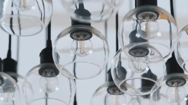 Expensive large glass chandelier in a restaurant or concert hall, shot with blurred focus and reflections — Vídeo de stock