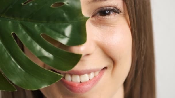 Gadis cantik dari penampilan kaukasia dengan daun hijau berpose di depan kamera — Stok Video
