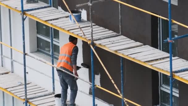 Rzemieślnicy na rusztowaniu na placu budowy tworzą fasadę — Wideo stockowe